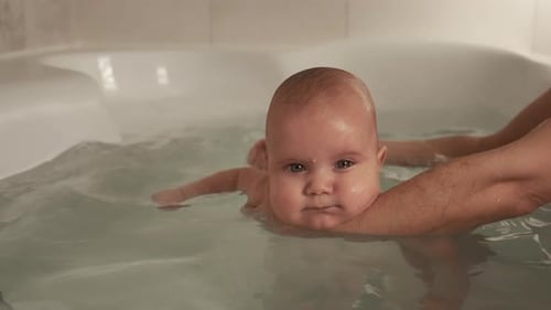 Infant Floating in Bathtub Receiving Gentle Bath