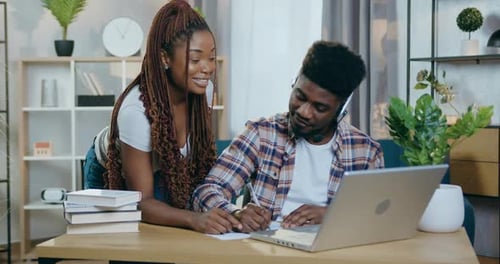 Pareja africana con emociones positivas mirando un portátil