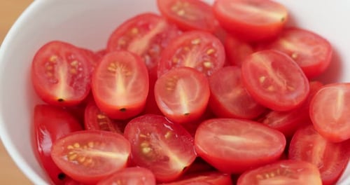 Fresh Red Cherry Tomatoes Halved in White Bowl