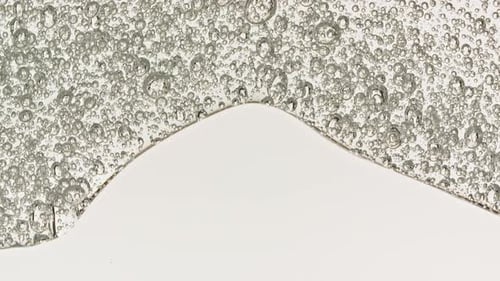 Transparent Cosmetic Gel Fluid With Molecule Bubbles Flowing On The Plain Surface