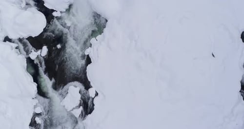 Bach fließt im Winter auf verschneiten Gebieten