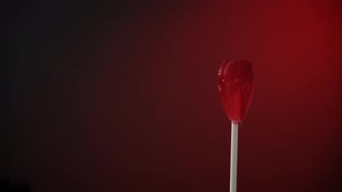 Red Heart Lollipop Spinning on Dark Background