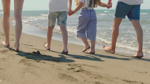 Close-up of bare feet walking in sand