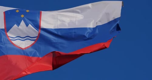 Flag of Slovenia Waving Against Blue Sky