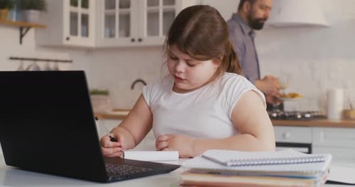 Girl Works on Laptop at Kitchen Table