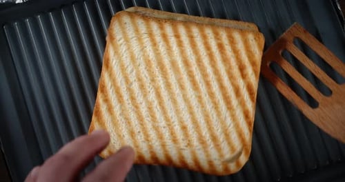Grilled Sandwich Being Turned with Wooden Spatula