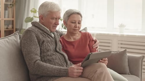 Senior Couple Relaxing with Tablet at Home
