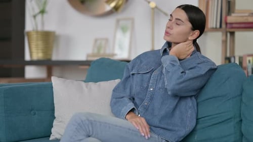 Woman Stretching Neck While Relaxing on Couch