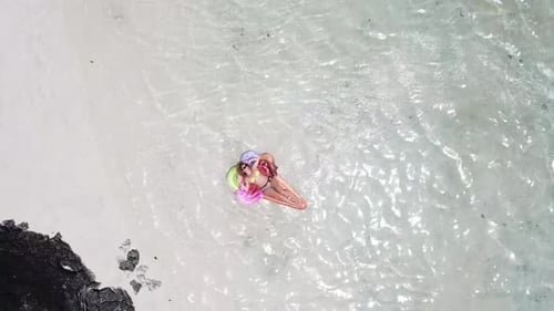 Aerial view of people in summer holiday vacation with beautiful girl on coloured trendy lilo