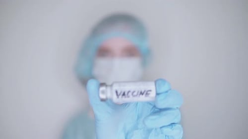 Medical Professional Holds Vaccine Vial in Close Up