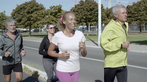 Happy Active Elder Joggers Running Down Street
