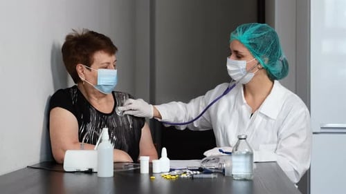 Doctor Examining Senior Woman By Stethoscope