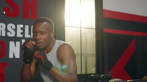 4K African man athlete do boxing exercise with punching the air at gym