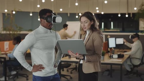 Innovation: Man Using VR Headset with Coworker