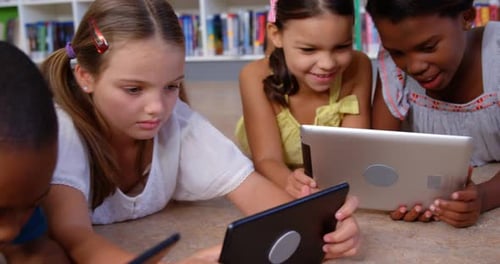 School kids and teacher using digital tablet in library