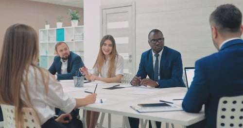 Internationales Team junger Geschäftsleute löst die finanziellen Probleme des Unternehmens