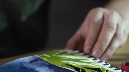 Concentrated Man Drawing Picture in Sketchbook