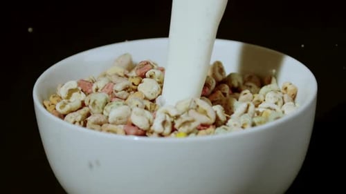 Milk Pouring Over Cereal in a White Bowl