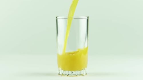 Saft gießt in Glas isoliert auf weißem Hintergrund