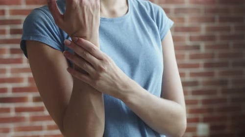 Frau massiert schmerzende Hand auf ihrem Arm Vorderansicht