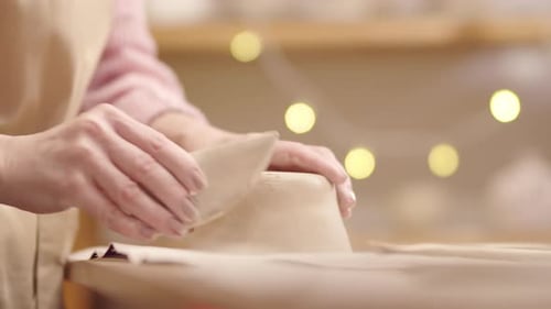 Woman Shaping Clay into Bowl in Pottery Studio