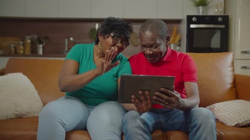 Senior Couple Video Chatting on Tablet at Home