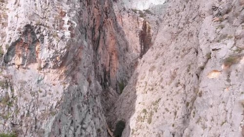 Drone flying through narrow rocky canyon.