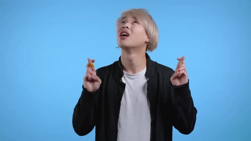 Young Adult with Crossed Fingers Hoping For Luck