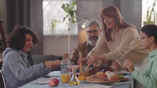 Family Eating Salad Together at a Dining Table