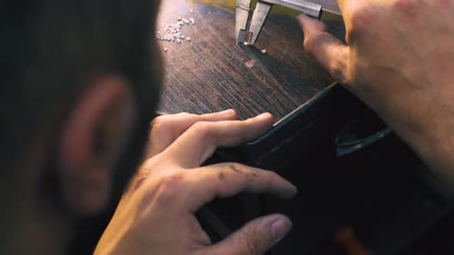 Jeweler Measuring Small Gems with Caliper Tool