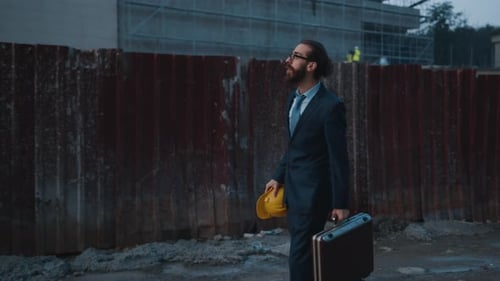 Construction Site Manager Walks By Building Works