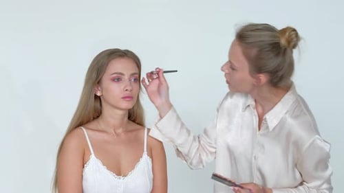 Makeup Artist Applying Eyeshadow to a Model