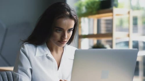 Young and Smart Woman Freelancing in Modern Cafe