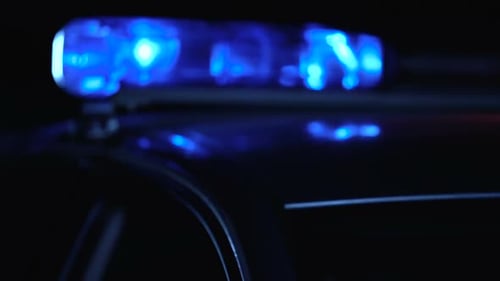 Polizeistreifenwagen blinkt ruhig auf Nachtstraße, Tatort, Recht und Ordnung