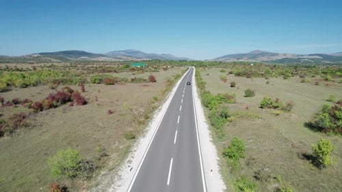 Aerial View Empty Asphalt Road on the Plateau Between Green Fields Highland Way