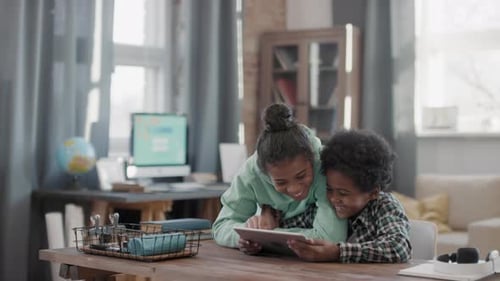 Two Children Looking at Tablet at Home