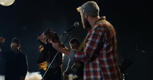Musician Performs on Stage with Dancing Crowd