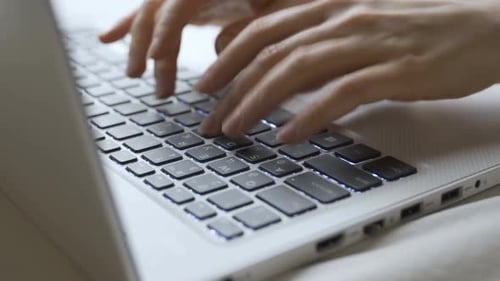 Frau tippt im Büro auf Laptop-Tastatur