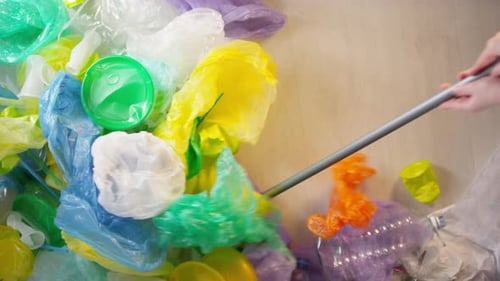 Sweeping Pile of Colorful Plastic Waste