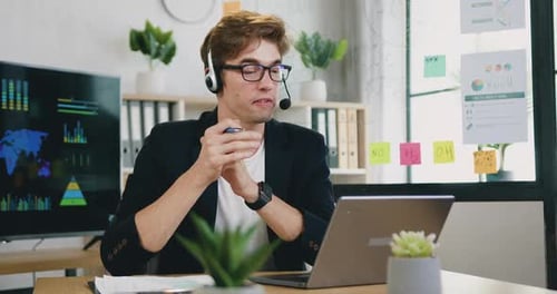 Un tipo con auriculares celebra una reunión en línea en el ordenador portátil con sus colegas y les da consejos