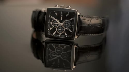 Close-Up of Elegant Black Watch on Reflective Surface
