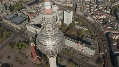 AERIAL: Wide View of the Top of Alexanderplatz TV Tower with Empty Berlin, Germany Streets in