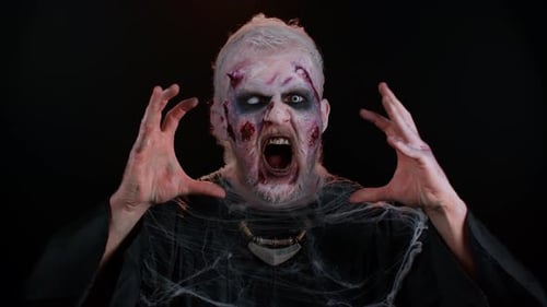 Zombie in Costume Screaming Against Black Background