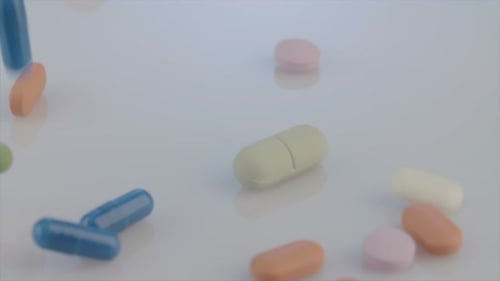 Colorful Pills and Capsules Falling on White Surface