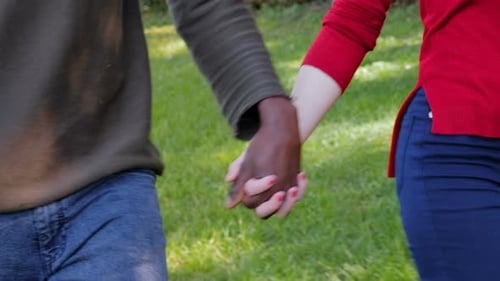 close up on Interracial love,romance concept.Black man hand holding white woman hand