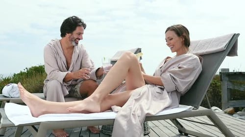 Couple Relaxing With Refreshments on a Deck