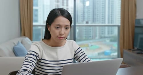Woman Working on Laptop in Urban Apartment