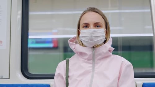 Woman with Protective Mask on Face Sitting in Subway Car, Looking Worried. Preventive Measures in