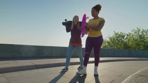 Two Friends Walk with Skateboards on Sunny Day