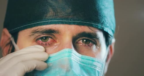 Tearful Health Worker in Surgical Cap and Mask